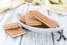 Crispy Waffles with Vanilla Cream (close-up shot) on wooden background
